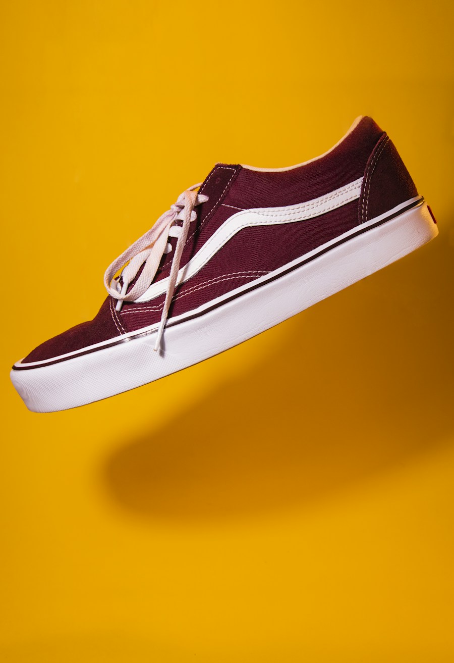 Burgundy retro sneaker floating on a yellow background